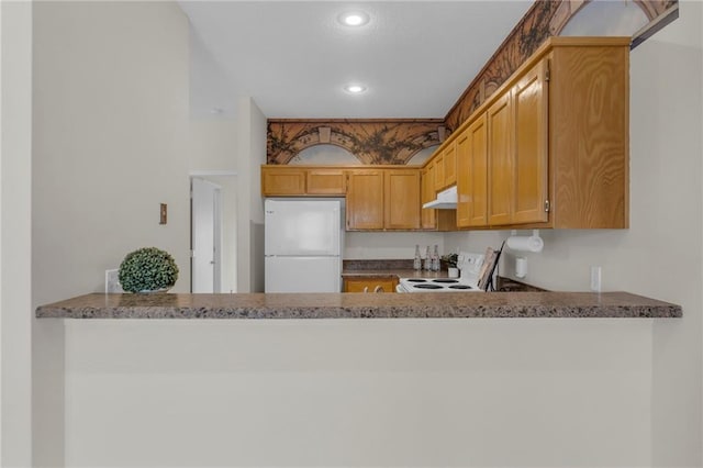 kitchen featuring white appliances, stone counters, a peninsula, recessed lighting, and under cabinet range hood