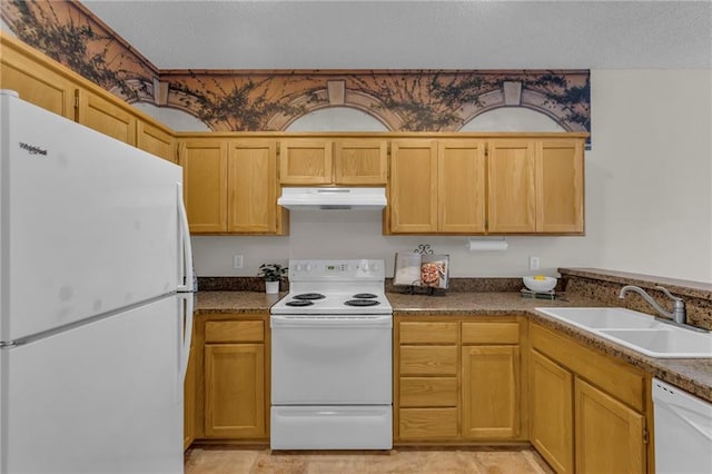 kitchen with white appliances, a sink, under cabinet range hood, a textured ceiling, and dark countertops