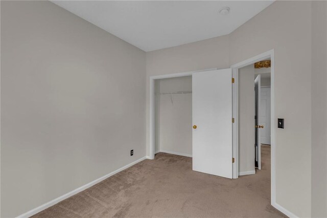 unfurnished bedroom featuring a closet, baseboards, and carpet floors