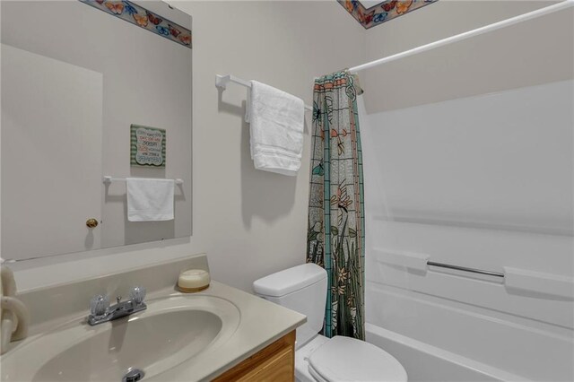 bathroom with vanity, shower / tub combo, and toilet