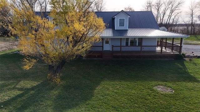 view of front of property with metal roof and a front lawn