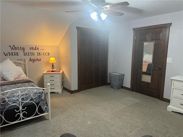 carpeted bedroom featuring a closet, baseboards, a ceiling fan, and vaulted ceiling