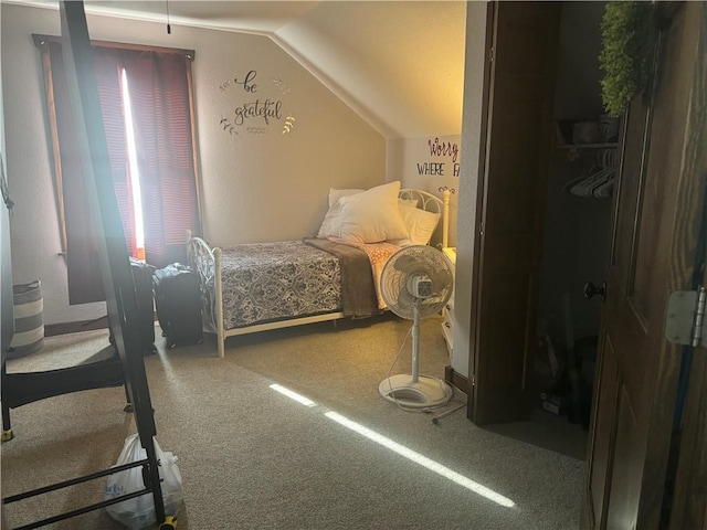 carpeted bedroom with lofted ceiling