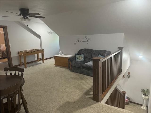 living area with baseboards, carpet, and vaulted ceiling