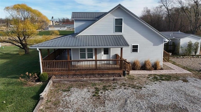 back of property featuring metal roof, a lawn, and a porch