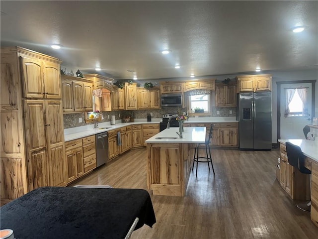 kitchen featuring a sink, stainless steel appliances, tasteful backsplash, and a healthy amount of sunlight