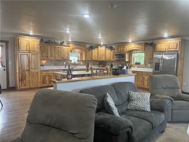 living area featuring light wood finished floors, plenty of natural light, recessed lighting, and baseboards