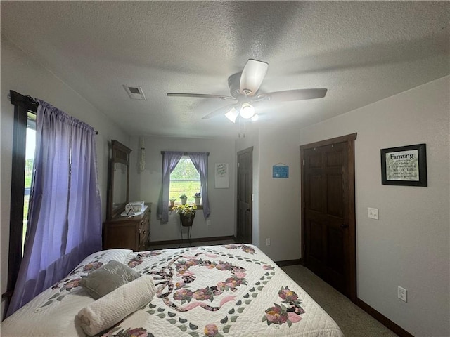 bedroom with visible vents, carpet flooring, a textured ceiling, and baseboards