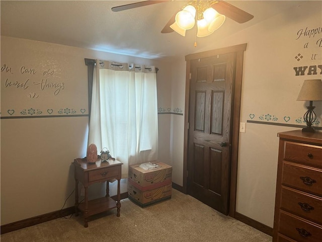 living area featuring baseboards, ceiling fan, and carpet flooring