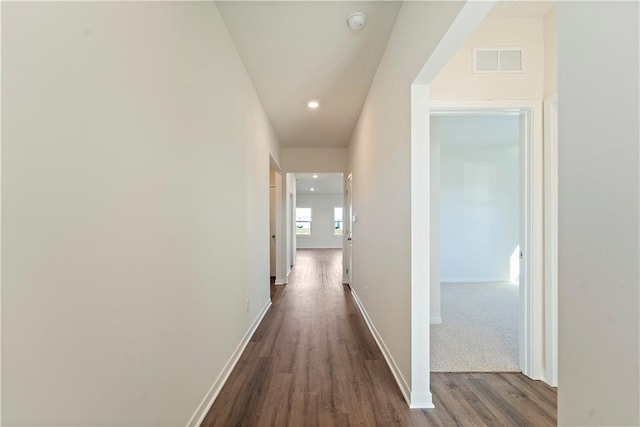 hallway with dark wood-type flooring, recessed lighting, visible vents, and baseboards