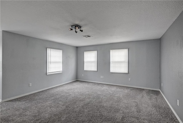 511 N E Ave, Columbus, KS 66725 - unfurnished room with carpet floors, healthy amount of natural light, a textured ceiling, and baseboards