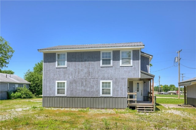 511 N E Ave, Columbus, KS 66725 - rear view of house with metal roof, a yard, and a porch