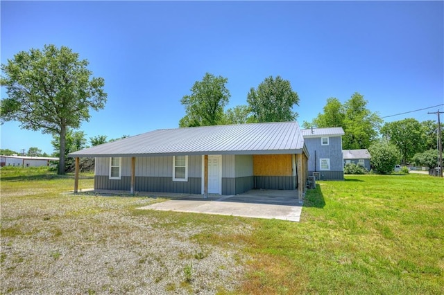 511 N E Ave, Columbus, KS 66725 - view of front facade with a front lawn, a carport, and metal roof