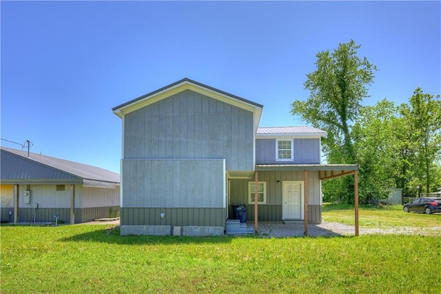 511 N E Ave, Columbus, KS 66725 - rear view of house featuring a lawn and metal roof
