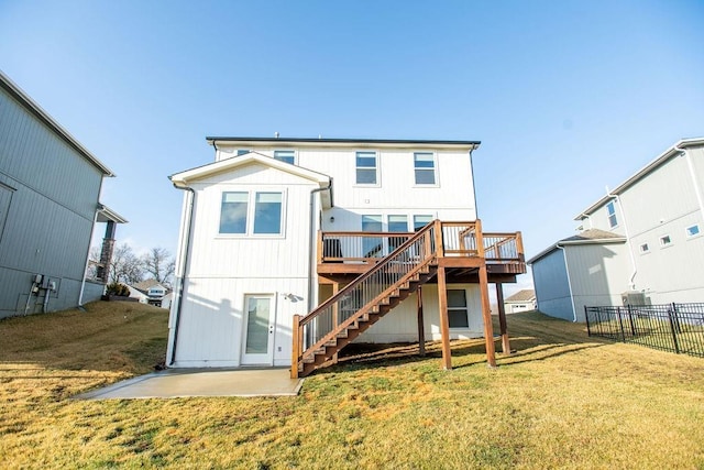 back of house featuring stairs, a yard, a wooden deck, and fence