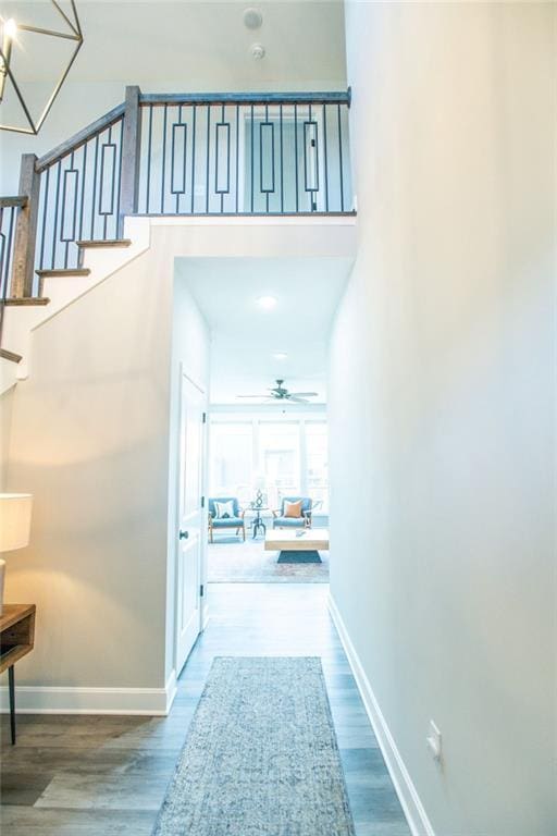 hallway featuring stairs, baseboards, and wood finished floors