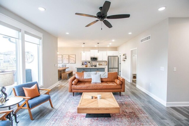 living room with a wealth of natural light, wood finished floors, and visible vents