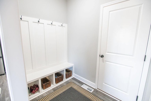 mudroom with wood finished floors, visible vents, and baseboards