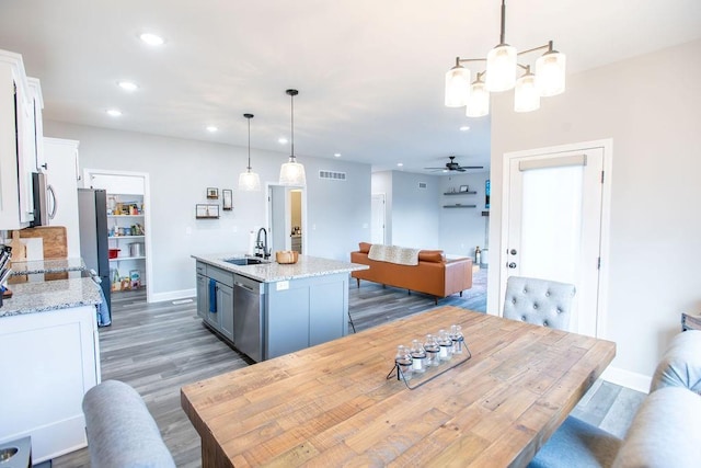 dining room featuring recessed lighting, ceiling fan with notable chandelier, wood finished floors, visible vents, and baseboards