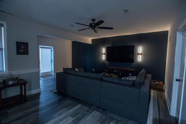 living area featuring a ceiling fan, baseboards, visible vents, and wood finished floors