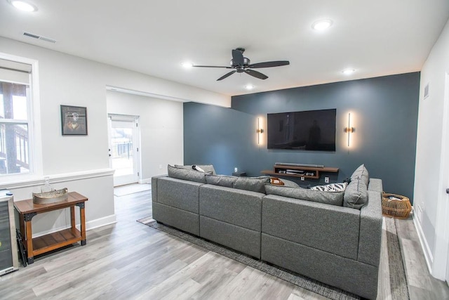 living area with recessed lighting, wood finished floors, visible vents, and a healthy amount of sunlight