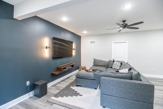 living area featuring light wood-style floors, visible vents, ceiling fan, and baseboards