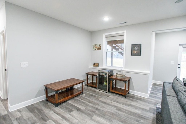 living area with wine cooler, recessed lighting, wood finished floors, and baseboards