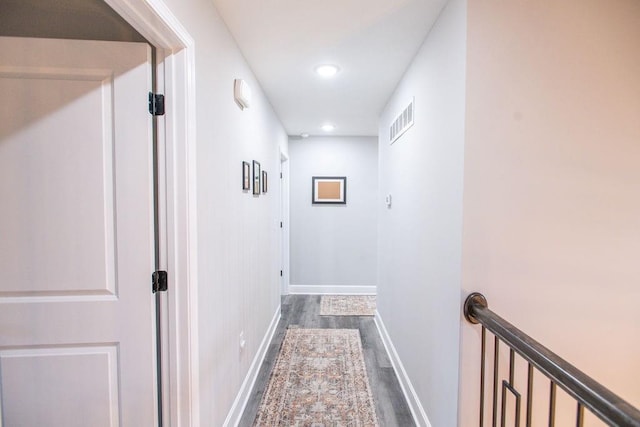 hallway featuring baseboards, visible vents, dark wood-style flooring, and recessed lighting