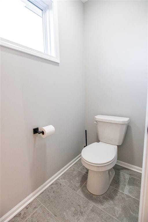 bathroom with toilet and baseboards