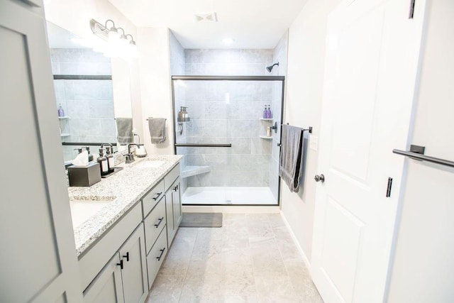 bathroom with double vanity, a shower stall, visible vents, and a sink