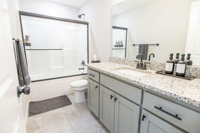 full bath featuring shower / bath combination with glass door, vanity, and toilet