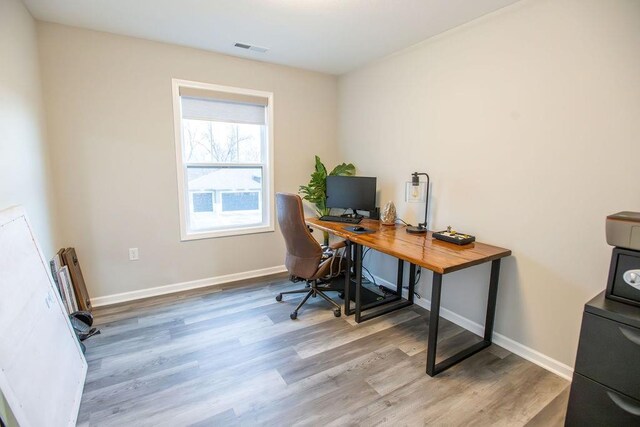 office area with baseboards, visible vents, and wood finished floors