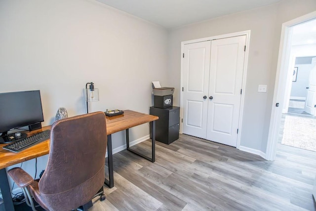 office area featuring light wood-type flooring and baseboards