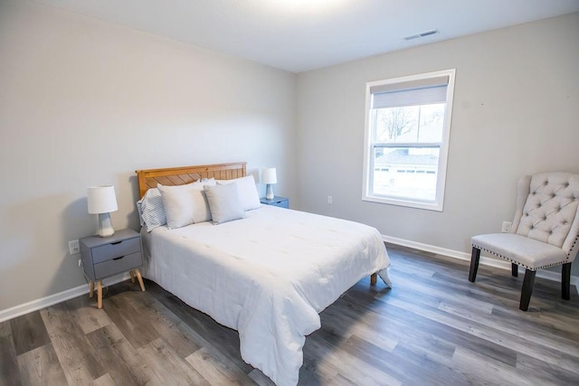 bedroom featuring wood finished floors, visible vents, and baseboards