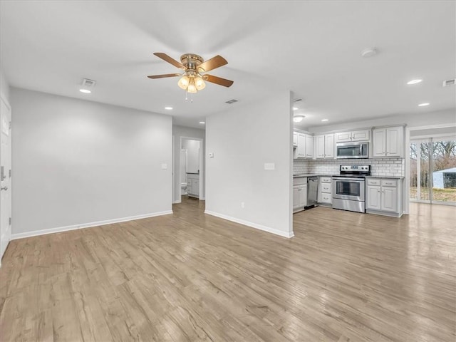 unfurnished living room with baseboards, visible vents, ceiling fan, and light wood finished floors