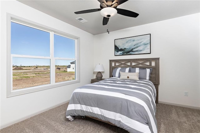 carpeted bedroom featuring baseboards, visible vents, and a ceiling fan