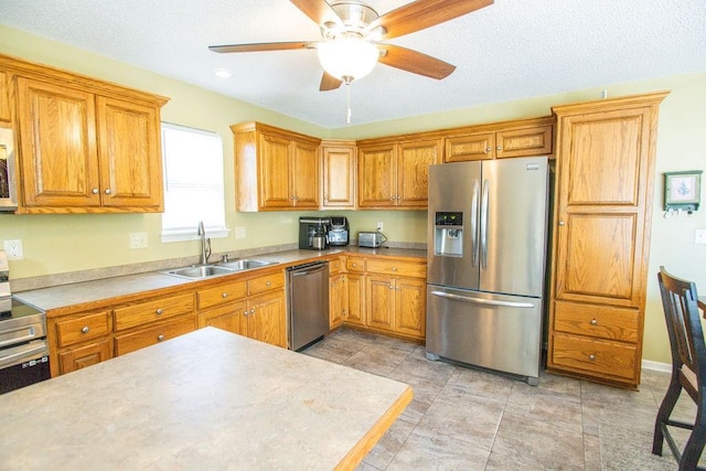 kitchen featuring brown cabinets, appliances with stainless steel finishes, and a sink