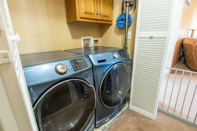 laundry area with visible vents, cabinet space, light carpet, and washing machine and dryer