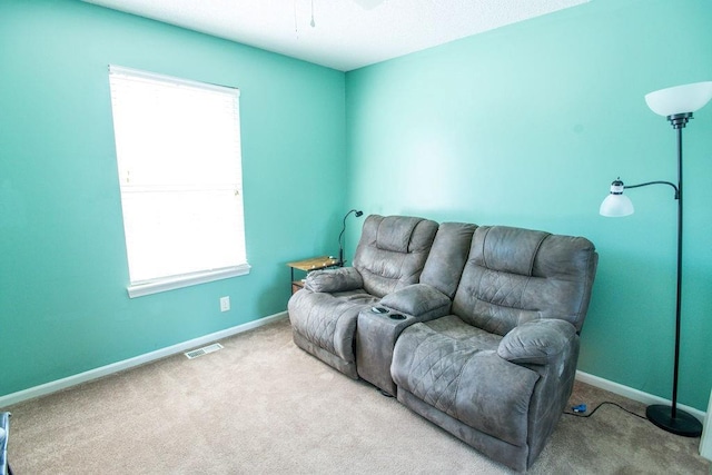 carpeted living room featuring visible vents, baseboards, and a wealth of natural light