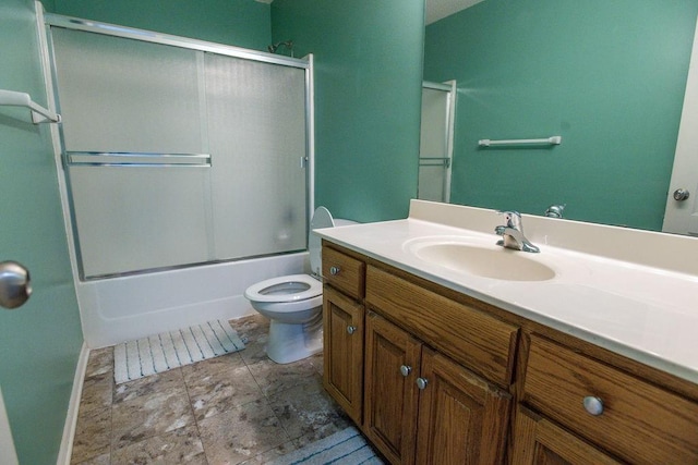 full bath with vanity, toilet, and bath / shower combo with glass door