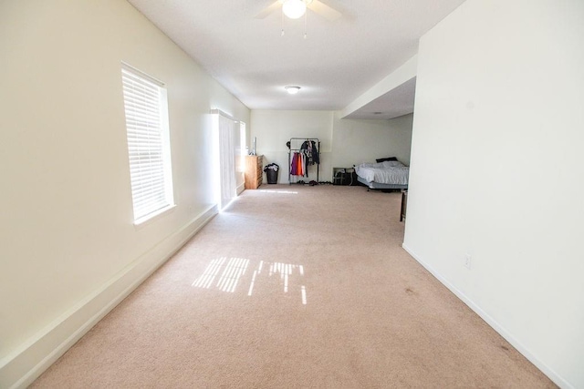 hall featuring carpet flooring and baseboards