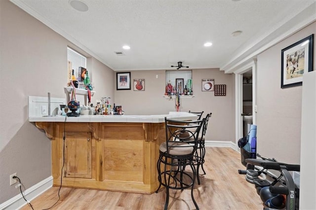 3820 Virginia Ave, Kansas City, MO 64109 - bar featuring visible vents, crown molding, baseboards, a bar, and light wood finished floors