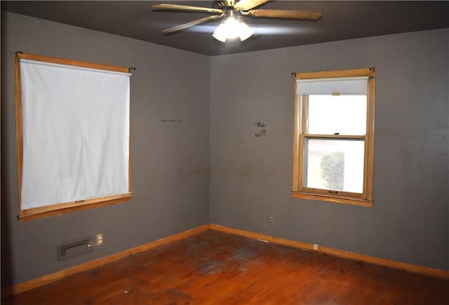 unfurnished room featuring ceiling fan, wood finished floors, and baseboards