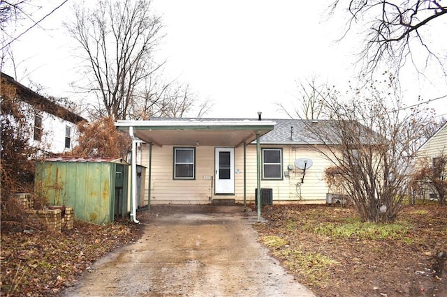 view of front of home with entry steps, concrete driveway, and a carport