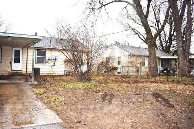 view of front of property with entry steps, roof with shingles, fence, and central AC