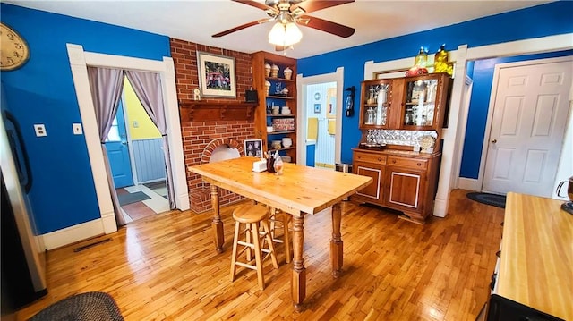 kitchen with baseboards, visible vents, light wood-type flooring, and ceiling fan