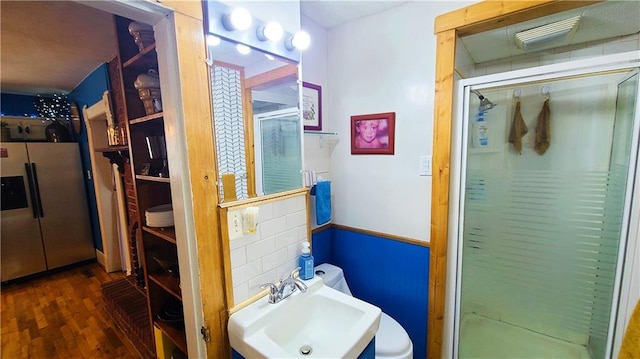 full bath featuring a sink, wood finished floors, and a stall shower