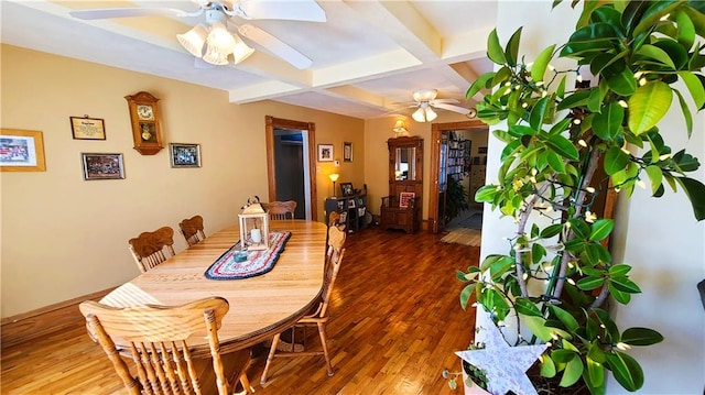 dining space featuring beam ceiling, wood finished floors, coffered ceiling, and ceiling fan