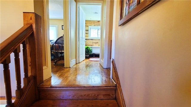 hallway with hardwood / wood-style floors, stairway, and baseboards