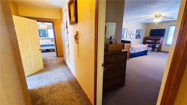 corridor featuring baseboards and carpet